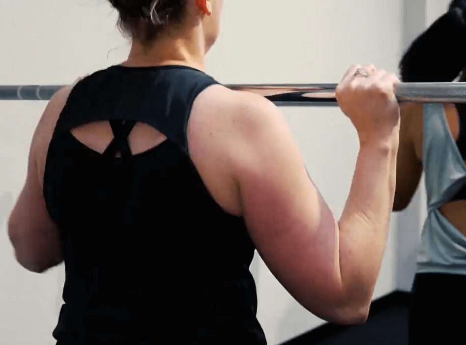 Woman lifting a barbell during a strength session at MFW Fitness Studio